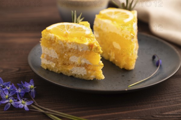 Lemon cake on brown wooden background and linen textile, cup of coffee, side view, close up,