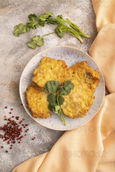 Fried crispy Chicken pancakes on brown concrete background and orange linen textile. top view, flat