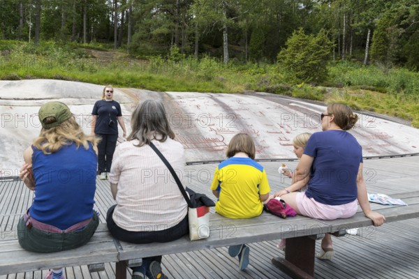 Historic rock carvings in Tanum, here at the Vitlycke site, tourist tour, figurative depiction from