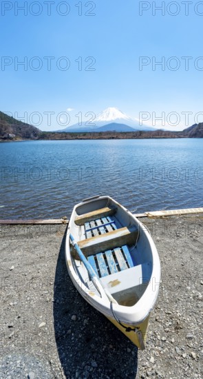 Rowing boat on shore, view across the lake to Mt Fuji volcano, Motosu Lake, Yamanashi Prefecture,
