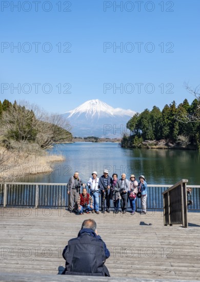 Japanese tour group takes souvenir photo, Fuji-mae observation deck, Mount Fuji volcano and Lake