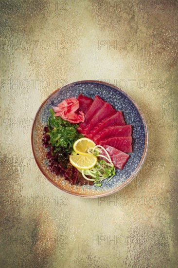 Tuna sashimi with daikon and wakame salad, pickled ginger, in a bowl