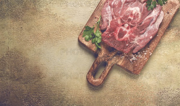 Raw steak, veal neck on the bone, fresh meat, on a cutting board, with spices, top view, without