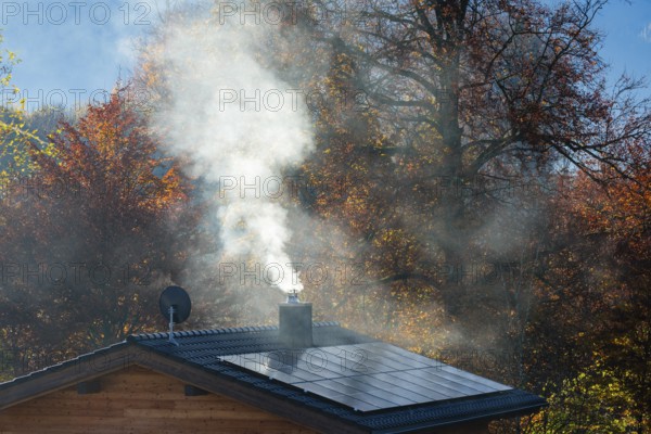 White smoke from fireplace on roof with solar cells, Bischofswiesen, Berchtesgadener Land, Upper