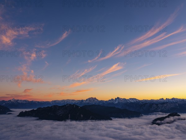 Red-colored plume clouds over the Berchtesgaden Alps at dusk, fog in the valley, Hochstaufen,