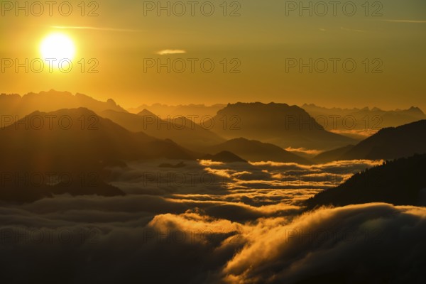 Silhouette of mountains at sunset, fog in valley, Wilder Kaiser and Chiemgau Alps, Upper Bavaria,