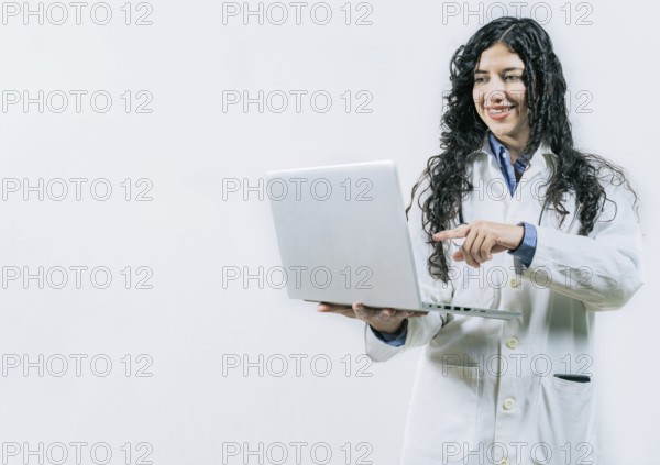 Smiling Woman doctor using laptop on isolated background. Female young doctor using and pointing