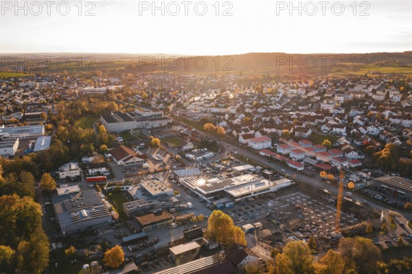 Small town with industrial facilities in warm evening autumn light, Grossbottwar, Germany