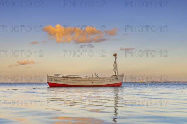 Wooden fishing boat anchored in the Bay of Lübeck, Lübecker Bucht in front of Sierksdorf at sunset,