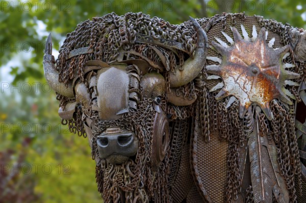 Close-up of life-size bison metal sculpture made out of discarded farm equipment, chains and bronze