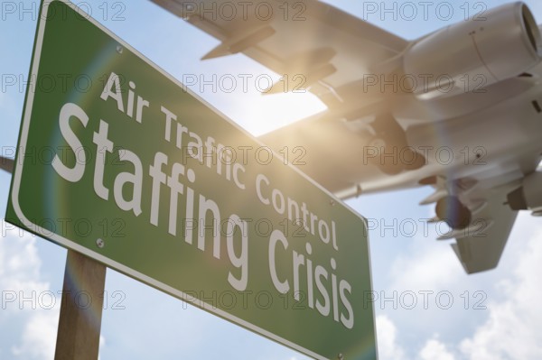 Air traffic control staffing crisis green road sign with airplane above