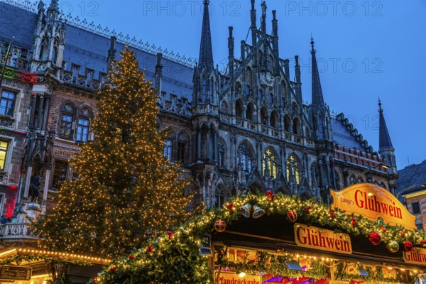 Mulled wine stand at the Christmas market, in the back the new town hall with illuminated Christmas