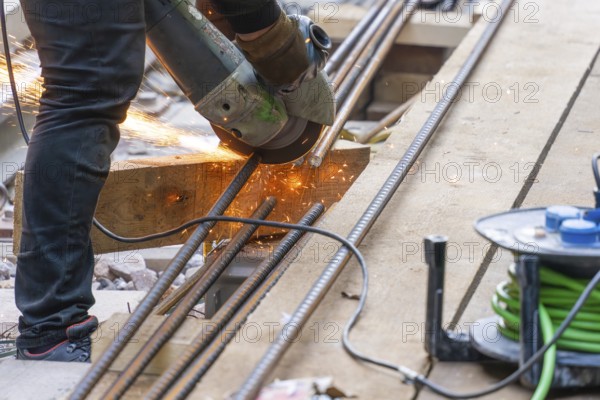 A construction worker cuts metal bars with a flex machine, Bau der Hermann, Hesse, Bahn, Calw,