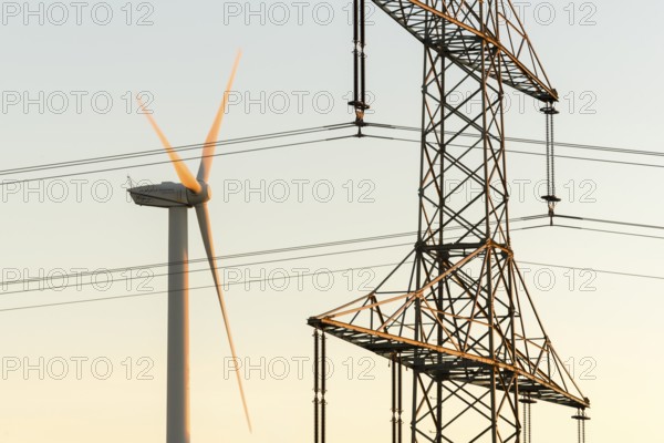 Wind turbine next to a power pole with wires, technical motif, Swabian Jura, Baden-Württemberg,