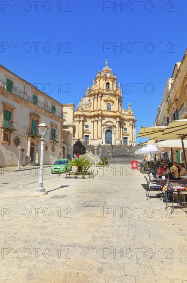 Tourists sitting in local restaurants in the main square, Ragusa Ibla, Ragusa province, Sicily,