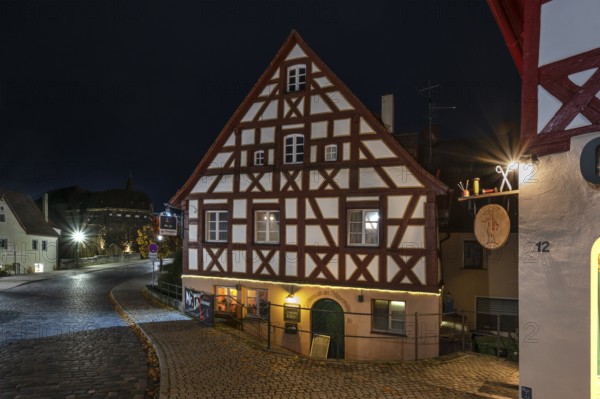 Night view of the historic half-timbered house, on the right the nose sign of a tailor shop, Lauf