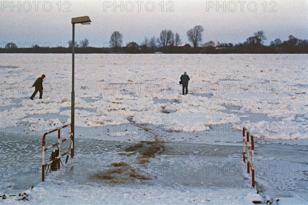 People walk across ice rink, ferry dock, frozen Elbe, Bleckede, Lower Saxony, Germany, January 03,