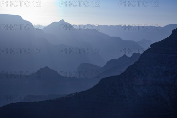 Scenic layers of the grand canyon in the early morning with hikers cabin roof shining in the lower