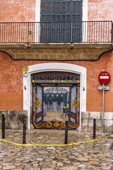 Restaurant with roll-down shutter blinds with graffiti painting on a street corner in the city,