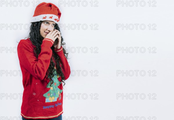 Woman in Christmas sweater secretly calling by phone. Girl in Christmas hat talking on the phone