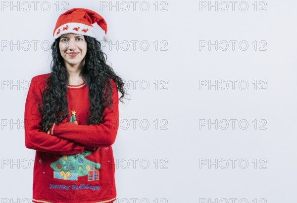 Portrait of smiling Latin girl in Christmas sweater with crossed arms, isolated. Smiling girl in