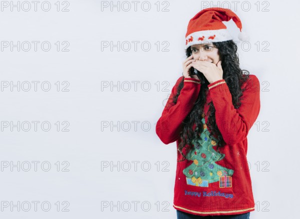Girl in Christmas hat talking on the phone secretly. Woman in Christmas sweater secretly calling by