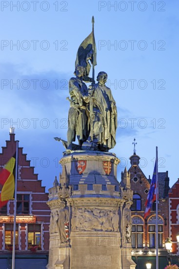 Illuminated monument to Jan Breydel and Pieter de Coninck in the evening light on the market square
