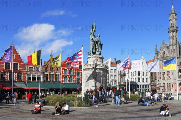 Monumental monument to Jan Breydel and Pieter de Coninck in front of historic houses on the lively