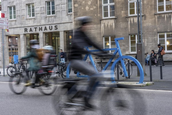 Bicycle parking spaces, with so-called leaning bars and a large blue bicycle silhouette, to make