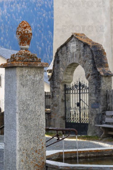 Village fountain in front of the entrance to the Firedhof, Tor, Guarda Engadin, Graubünden,