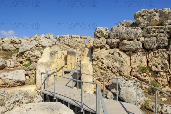 View from secured walkway with railing through ruins remains of Ggantija temple, UNESCO World