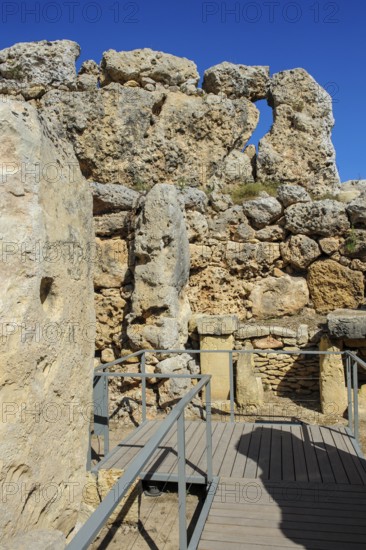 View from secured walkway with railing through ruins remains of Ggantija temple, UNESCO World