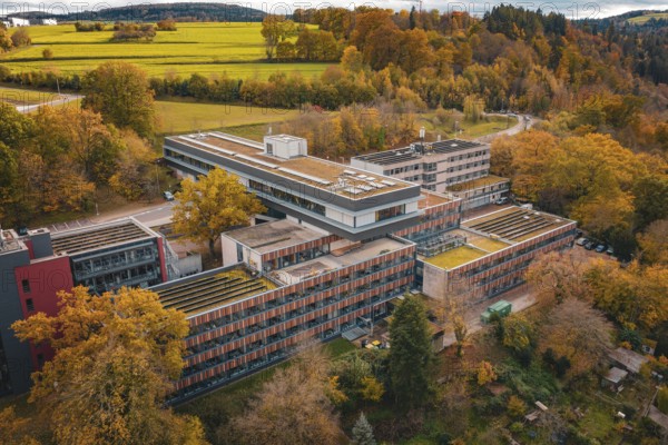 Building complex surrounded by autumnal nature with advanced roof design, Calw District Office,