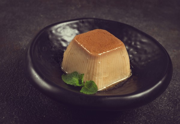 Cream caramel pudding, with caramel sauce, dessert, breakfast, on a black plate, mint, no people