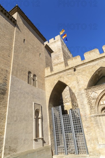 Looking up at historic tower and ramparts in courtyard of historic castle, Aljafería Palace,
