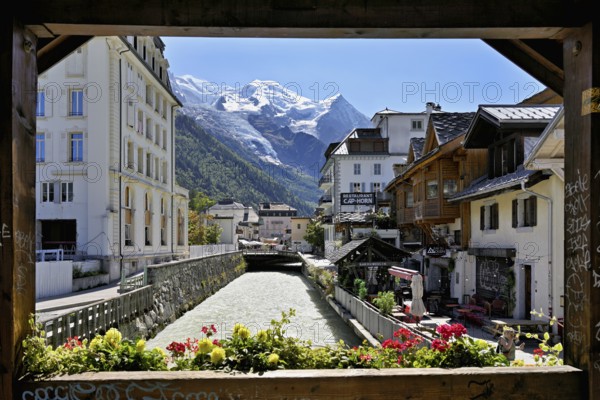 Glacier river Arve flows through the city, with the snow-capped Mont-Blanc mountain range behind,
