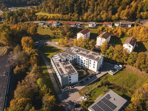 Aerial view of an autumnal residential area with solar panels and surrounding trees, Nagold, Black