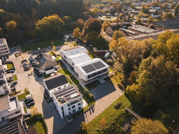 Picturesque overview of a small settlement with solar panels on the roofs in autumn surroundings,