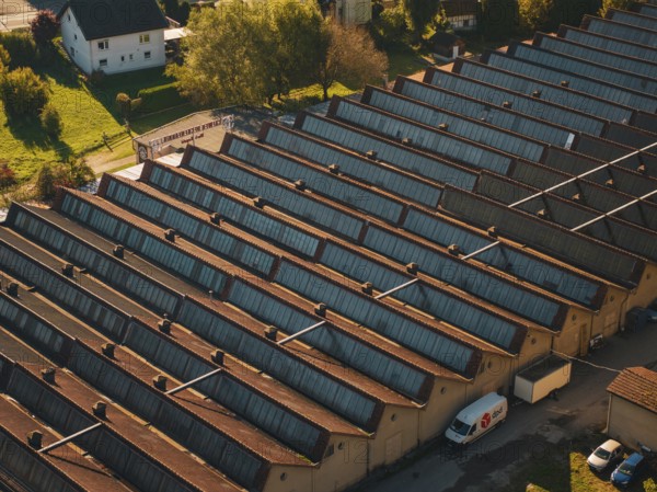 Industrial roof structure with a delivery vehicle in an autumn light, seen from the air, Nagold,