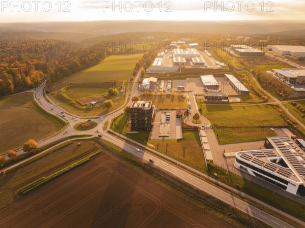 Overview of a large industrial area in the evening light, surrounded by fields and hills, Nagold,