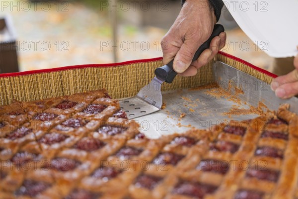 Hand cut a raspberry pastry with a scraper on a baking tray, Streuobstmarkt, Sindelfingen,
