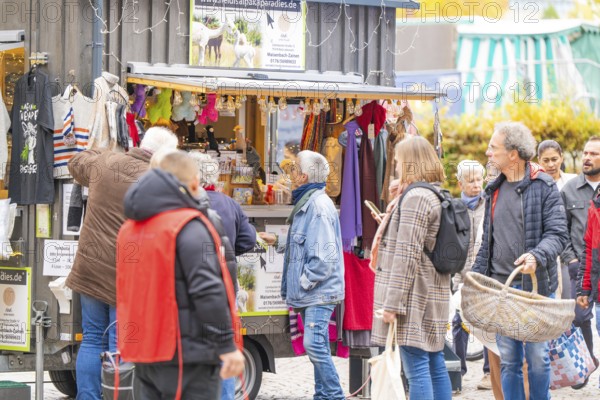 Busy market stand with people inspecting clothes and accessories, Streuobstmarkt, Sindelfingen,