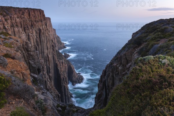 The Gap with long exposure shows the sunset over the cliffs of Cape Raoul. Golden light hits the