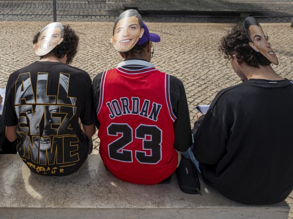 Street art, young people with Ronaldo mask on the back of their heads taking part in a school