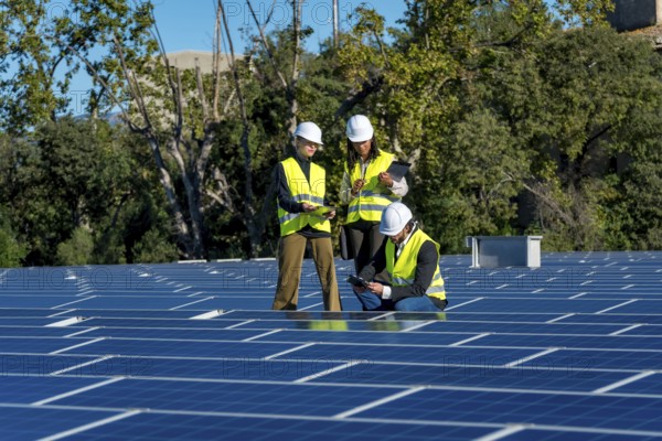 Team of diverse engineers in safety hardhats and vests are collaborating and inspecting the