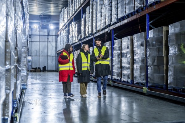 Diverse logistics team is walking and discussing inventory management within a modern cold storage