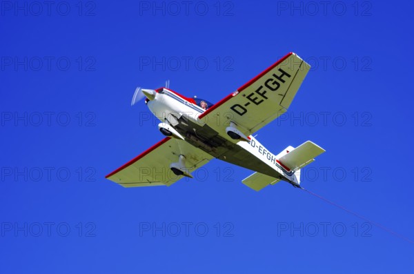 A Robin DR 400/200R Remorqueur light aircraft, registration D-EFGH, tows a glider during a flight