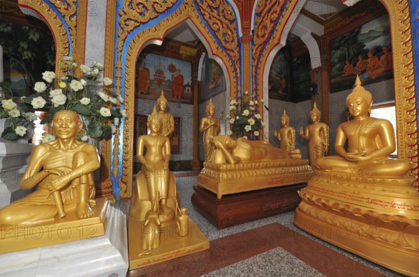 Prayer room devotional room with golden statues from left Monk and Buddha in the temple complex Wat