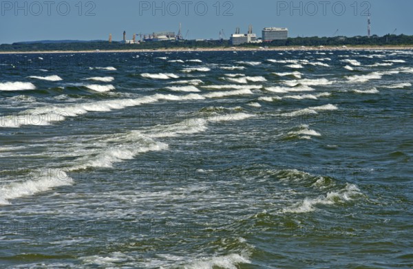 Baltic Sea waves, waves wash on the beach at the seaside resort of Ahlbeck, behind the skyline of