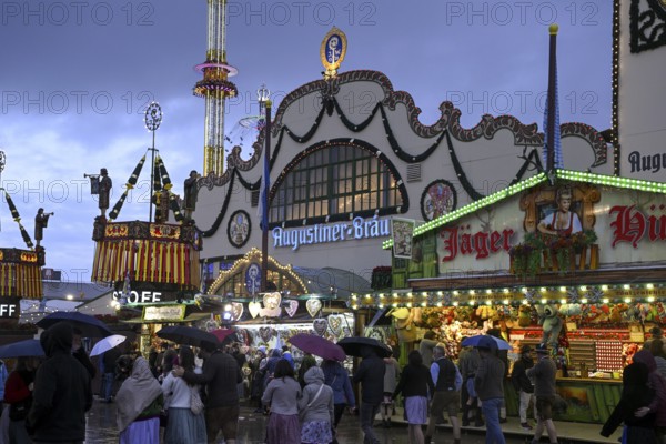 Oktoberfest visitors with umbrellas, rainy meadows, Augustiner festival tent, Munich, Bavaria,